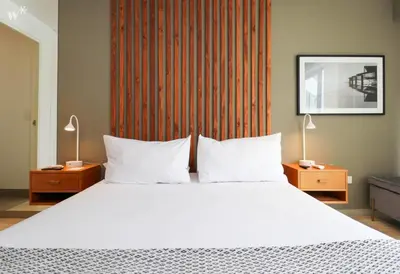 a bedroom with a large white bed with two lamps at Primera Parada By Wynwood House in Lima