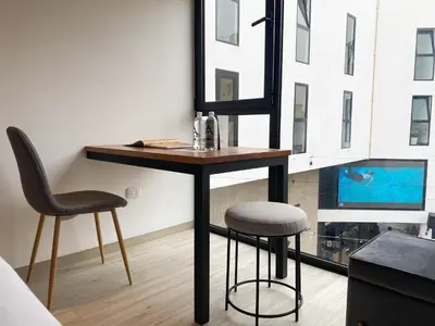 a table and two stools in a room with a mirror at Primera Parada By Wynwood House in Lima