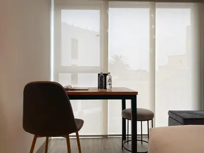 a desk and two chairs in a room with a window at Primera Parada By Wynwood House in Lima