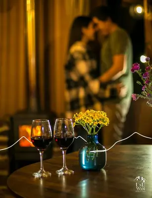 two glasses of wine and a vase with flowers on a table at Unuwasi Hotel & Villa in Calca