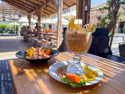a drink and a plate of food on a table at Viajero Paracas Hostel in Paracas