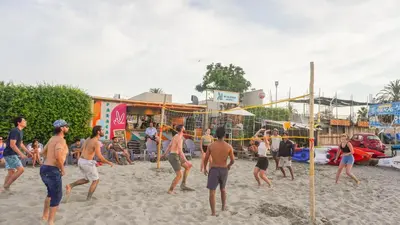 a group of people playing volley ball on a beach at Viajero Paracas Hostel in Paracas