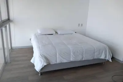 a white bed with two pillows on it in a bedroom at Barranco Penthouse ocean boardwalk in Lima