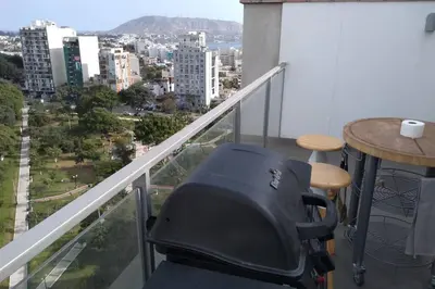 a chair on a balcony with a view of a city at Barranc Group Penthouse in Lima