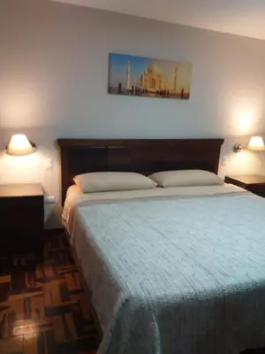a bedroom with a large bed with a blue blanket at Apart Hotel Don Ernesto in Lima