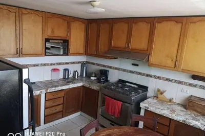 a kitchen with wooden cabinets and a stove top oven at Apart Hotel Don Ernesto in Lima