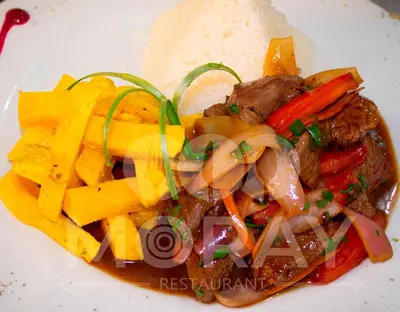 a plate of food with meat and vegetables and rice at Gran Hotel Ica in Ica