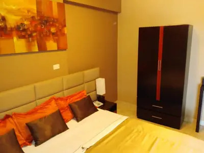 a bedroom with a large bed with orange pillows at Gran Hotel Ica in Ica