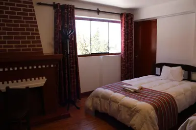 a bedroom with a large bed and a window at KAARO HOUSE CUSCO in Cusco