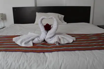 a towel animal is sitting on a bed at KAARO HOUSE CUSCO in Cusco