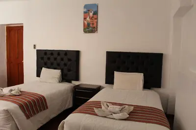 a bedroom with two beds with towels on them at KAARO HOUSE CUSCO in Cusco