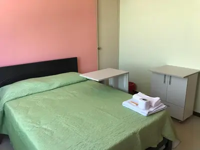 a bedroom with a green bed with two towels on it at Rooms MD in Huancayo