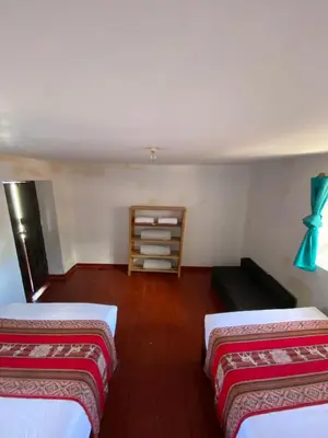 a room with two beds and a book shelf at CASA ANDINA PRIVADA a lado del Museo - Qespiwanka in Urubamba