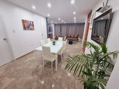 a dining room with a white table and chairs at Departamento exclusivo ica in Ica