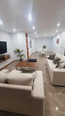 a living room with two white couches and a table at Departamento exclusivo ica in Ica
