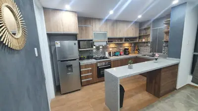 a kitchen with stainless steel appliances and wooden cabinets at Departamento exclusivo ica in Ica