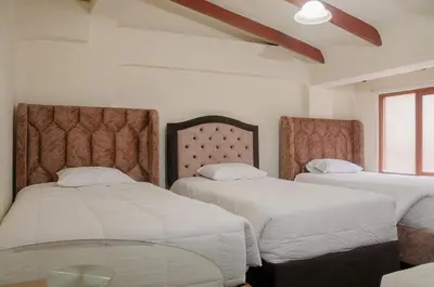 a bedroom with two beds and a glass table at Hostal Chasky in Cusco
