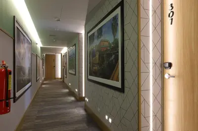 a hallway with paintings on the walls of a building at Casa Andina Standard Benavides in Lima