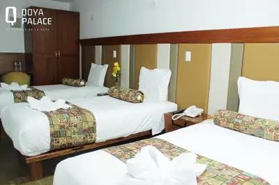 a hotel room with three beds and a phone at Hotel Qoya Palace - Machupicchu in Machu Picchu