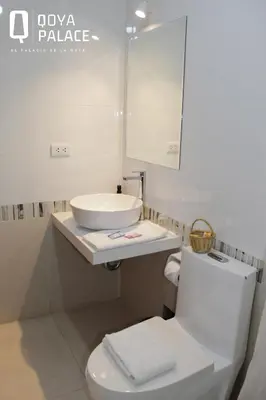 a white bathroom with a sink and a toilet at Hotel Qoya Palace - Machupicchu in Machu Picchu