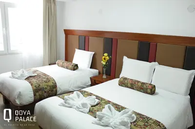 two beds in a hotel room with flowers on them at Hotel Qoya Palace - Machupicchu in Machu Picchu