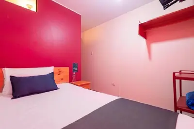 a bedroom with a large bed with a red wall at Hotel Savoy Ica in Ica