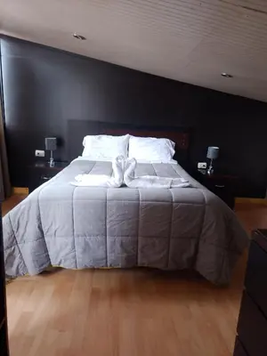 a bedroom with a large bed with two pillows at Casa Salkantay Mini Departamento in Cusco