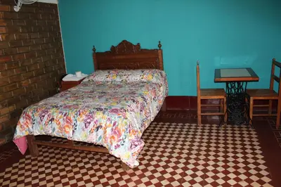 a bedroom with a bed and a blue wall at Hostal Loma Blanca in Ica