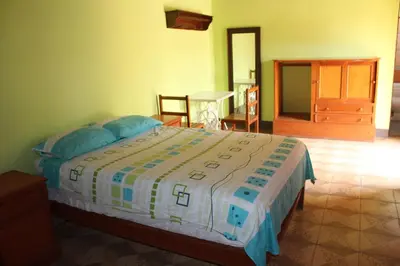 a bedroom with a bed and a table and chairs at Hostal Loma Blanca in Ica