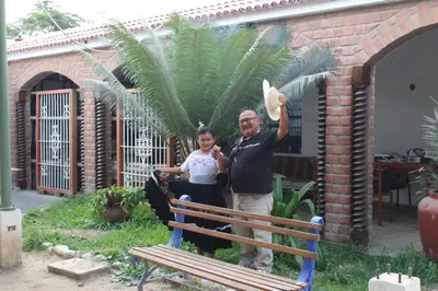 a man and a woman standing next to a bench at Hostal Loma Blanca in Ica