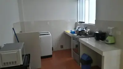 a small kitchen with a sink and a stove at Hermoso departamento en chorrillos in Lima