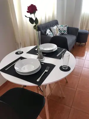 a white table with plates and utensils on it at Hermoso departamento en chorrillos in Lima