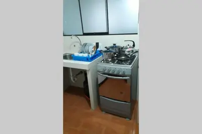 a small kitchen with a stove and a sink at Hermoso departamento en chorrillos in Lima