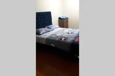 a bedroom with a bed with a blue comforter at Hermoso departamento en chorrillos in Lima