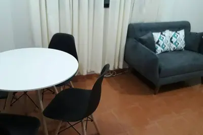 a living room with a table and chairs and a couch at Hermoso departamento en chorrillos in Lima