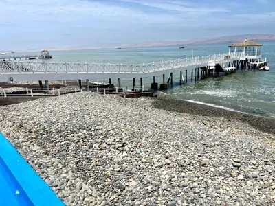 a pier on a rocky beach next to the water at Paracas Paracas! Vista Bahia - Sotavento 201 T 6 in Paracas