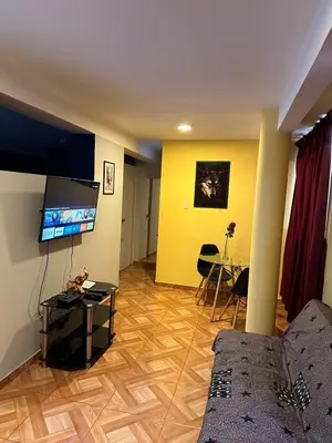 a living room with a television and a table with chairs at 300 Departamento Centrico distrito de chorrillos in Lima