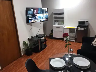 a living room with a table and a flat screen tv at 100- departamento céntrico en chorrillos in Lima