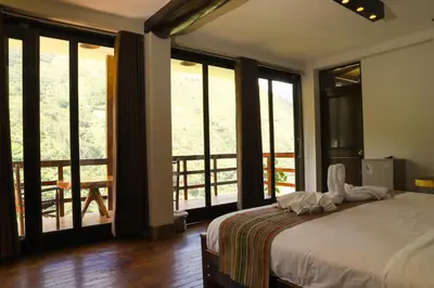 a bedroom with a bed and a balcony with windows at Vertikal lodge in Santa Teresa