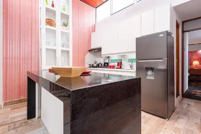 a kitchen with a black counter and a refrigerator at Loft abierto y moderno & Aire acondicionado in Lima