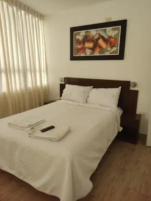 a bed with a blanket and a remote control on it at Villa blanca in Andahuaylas