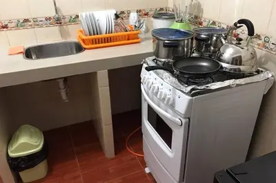 a kitchen with a stove with pots and pans on it at 201 Departamento exclusivo en Chorrillos in Lima