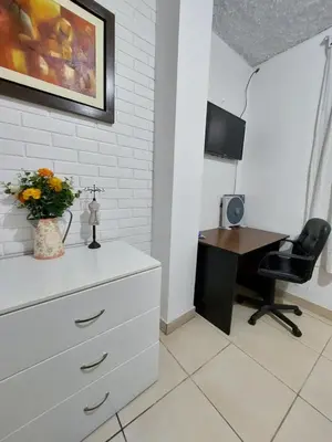 a bedroom with a dresser and a desk with a computer at Casa Amarello in Lima