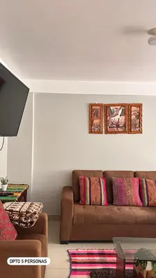 a living room with a brown couch with colorful pillows at El Viejo Roble in Cusco