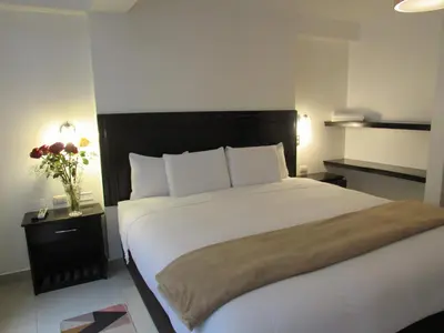 a bedroom with a large bed and a vase of flowers at Quilla House Ecologico in Machu Picchu