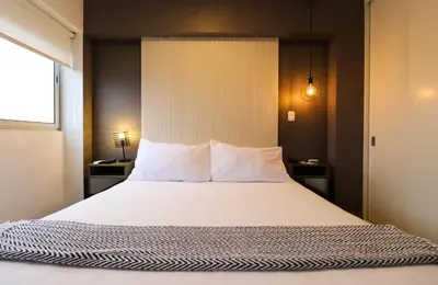 a bedroom with a large bed with white pillows at Connect by Wynwood House in Lima