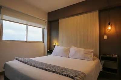 a bedroom with a white bed with a window at Connect by Wynwood House in Lima