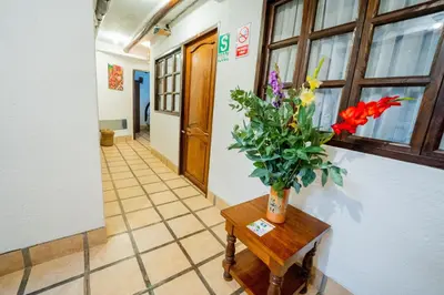 a hallway with a vase of flowers on a table at Vilas Insight Hotel Machupicchu in Machu Picchu