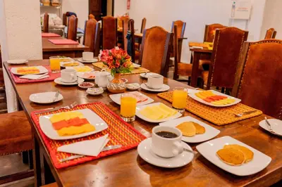 a wooden table with plates of food on it at Vilas Insight Hotel Machupicchu in Machu Picchu