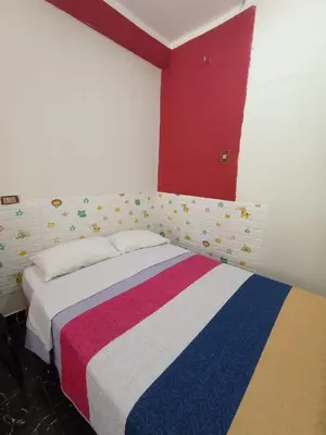 a bedroom with a bed with a colorful blanket on it at La Esquina de Doña Julia in Lima